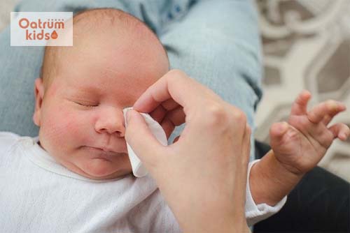Lau nhẹ nhàng cho vùng mắt của trẻ sơ sinh bị tắc tuyến lệ